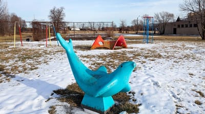 A turquoise Jim Miller-Melberg play sculpture in a snowy playground