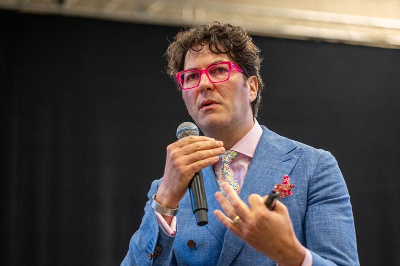 Adam Rozan speaking into a microphone at the Texas Association of Museums Annual Meeting